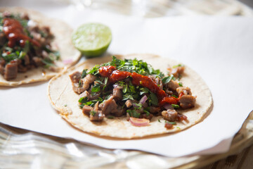 Delicious Mexican tacos with handmade tortillas with beef and spicy red sauce.