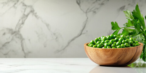 Green peas in wooden bowl with parsley on marble surface. Food and cooking backgrounds