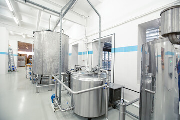 Modern manufacturing facility with stainless steel tanks and piping for processing materials