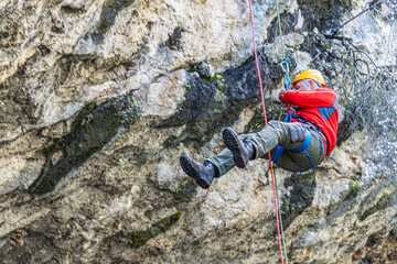 Obraz premium Rock climber is belaying in front of Kocain Cave, Döşemealtı, Antalya, Turkey