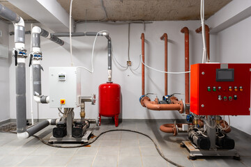 Water pump system installation in a basement utility room with various plumbing components and...