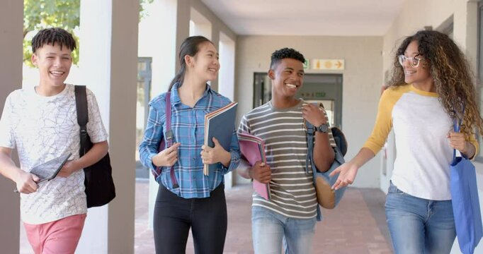 Diverse group of teenagers walking in a high school corridor