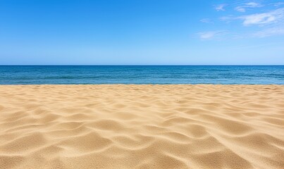 Fototapeta premium Empty sandy beach meets calm blue ocean under sunny sky, ideal summer vacation backdrop