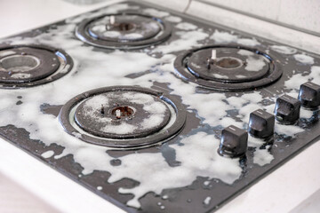 Cleaning a gas stove with kitchen utensils, household concepts, or hygiene and cleaning