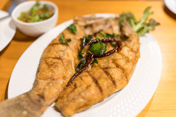 Fried sea bass with fish sauce. Close up