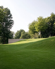 Lush green landscape with gentle hills and modern architecture during daylight