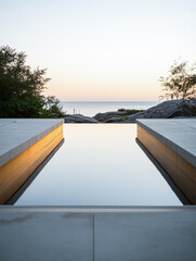 Serene reflection of water at dusk by the coastline creating a tranquil atmosphere