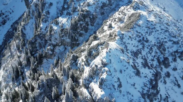 Aerial view of the snowy Malaiesti trail on Bucegi Mountains in central Romania, on a sunny day