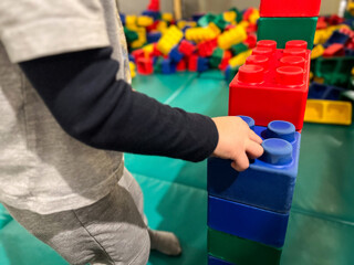 Close up of toddler playing at an indoor playground with blocks