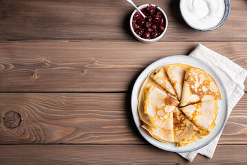 Homemade crepes pancakes with sour cream and cherry jam