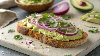 Close-up shot of a slice of toasted whole grain bread topped with creamy avocado spread sliced red onion and chopped fresh cilantro, avocado toast, , healthy snack