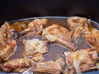 Baked pork ribs with onions. Ribs baked in an electric oven and onions added to the baking pan.