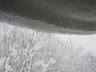 屋根にぶら下がる雪