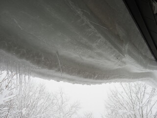 屋根にぶら下がる雪