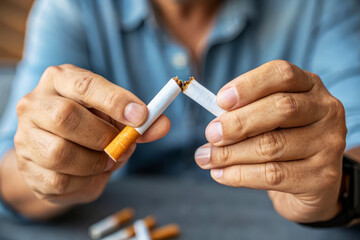 Person Breaking Cigarette in Effort to Quit Smoking and Embrace a Healthier Lifestyle