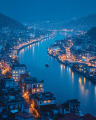 Fototapeta premium Night view of city illuminated along river, boat on water, hills in background; travel, tourism, cityscape
