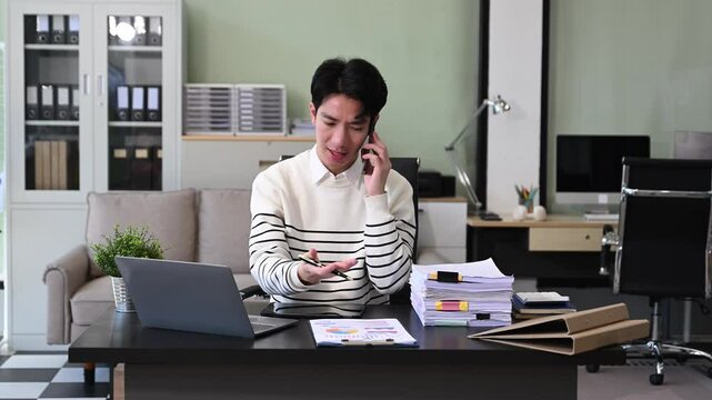 Young Businessman using laptop and tablet while sitting at her working place