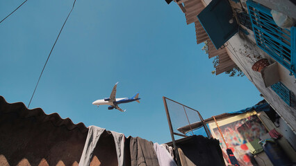 An airplane over the houses in Mumbai.