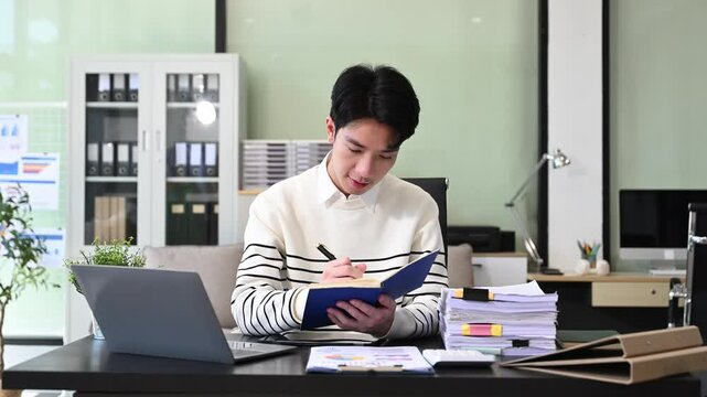 Young Businessman using laptop and tablet while sitting at her working place
