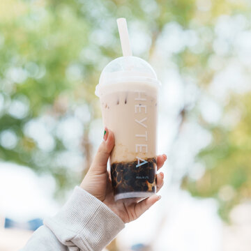 Woman hand holding brown sugar boba milk tea with tapioca pearls in HeyTea cafe, HeyTea a famous beverages brand in China. 6 December 2024, Shanghai, China