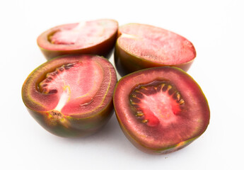 Black halves of tomatoes on white background