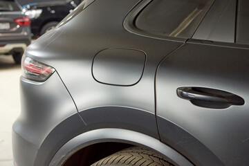 Installation of a protective paint and varnish matte film on the car. The PPF polyurethane film protects the car paint from scratches, blurry focus.