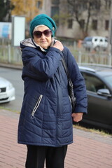 Portrait of an active elderly lady 89 years old on a walk in the city
