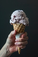 Hand holding an ice cream cone with dark bg