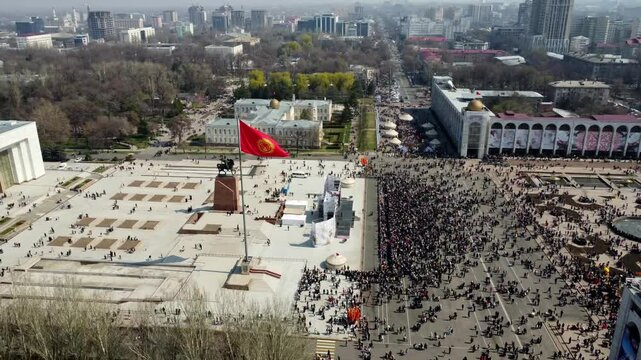 Flying around a flagpole national flag of Kyrgyzstan. Ala-Too central main square of country. Bishkek city center. Tourist attraction, travel destination, aerial