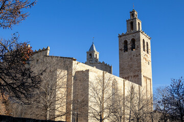 Ancient stone monastery with a tall bell tower, standing against a clear blue sky.  The architecture is impressive, showcasing a rich history.