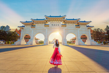 Asian woman walks in the Archway of Chiang Kai Shek Memorial Hall, Tapiei, Taiwan. The meaning of the Chinese text on the archway is "Liberty Square".