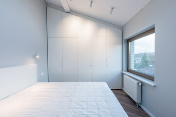 Modern Minimalist Luxury Home Bedroom Interior with White Wardrobe and Natural Light