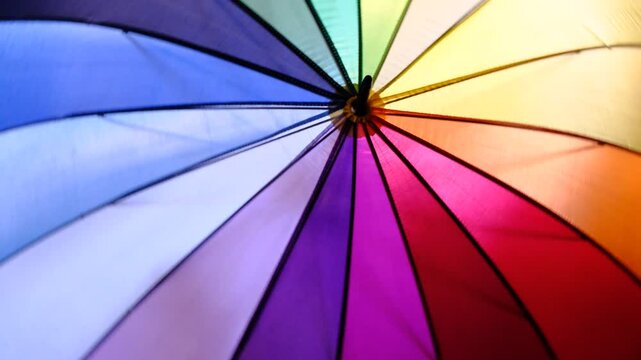 A rainbow color umbrella spinning