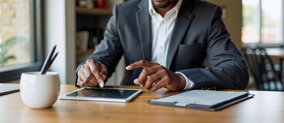 Man Sitting at Table with Tablet and Cup Enjoying His Time