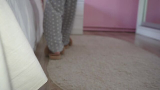 child goes to the bedroom and goes to sleep on the bed, feet child in slippers goes to the bedroom and lies on the bed and covers himself with a blanket