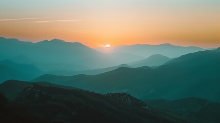 Obraz premium A beautiful, layered mountain range against a colorful sunset sky.