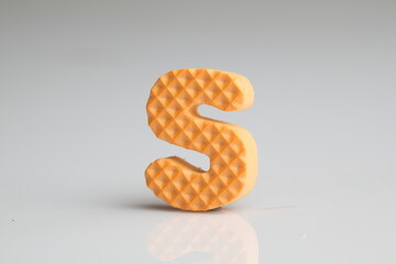 S in colorful foam on a white background