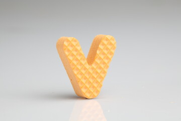 V in colorful foam on a white background