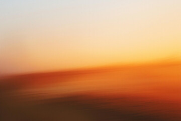 Fototapeta premium Abstract sunset with soft colors blending in the sky, creating a serene atmosphere over a landscape