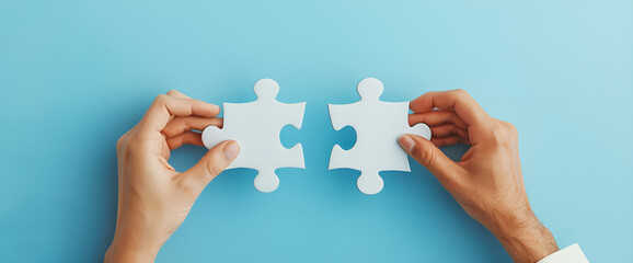 Dwie dopasowujące się puzzle w rękach na niebieskim tle.