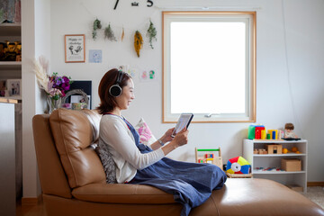 Japanese Pregnant Woman Video Calling a Friend on a Tablet at Home