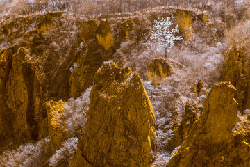 Infrared style, rugged rock formations with prominent cliffs. The colors have a warm, yellowish tone