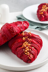Red velvet croissant on a white plate.