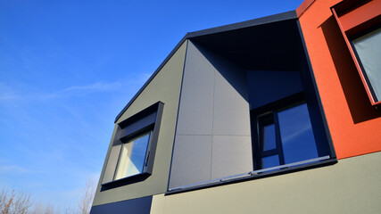 Terraced family homes in newly developed housing estate. The real estate market in the suburbs. New single family houses in a new development area. Residential homes with modern facade. 