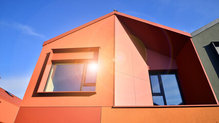 Terraced family homes in newly developed housing estate. The real estate market in the suburbs. New single family houses in a new development area. Residential homes with modern facade. 