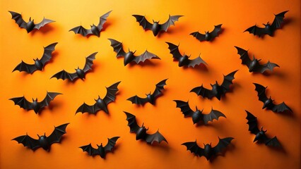 Fototapeta premium A Flock of Black Bats on an Orange Background for Halloween Decorations