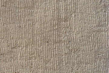 A detail of a facade with parallel grooves with a crack