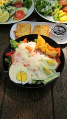 colorfull salad with vegetables in a black bowl