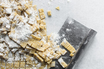 Nigerian Chin chin dough on a white granite countertop, Raw chin-chin on a chopping board, process...