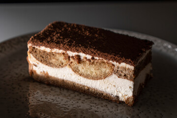 Tiramisu cake dessert served with coffee, biscuit and cocoa on dark background.spoon. Dessert. Food Concept